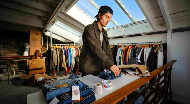 A man packing vintage clothes for shipping